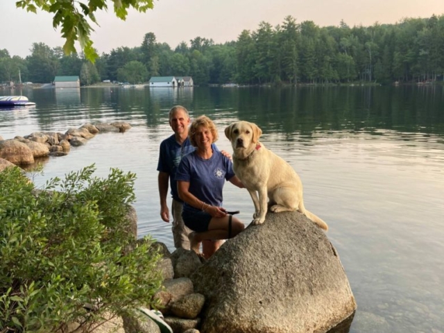 family with dog on a lake